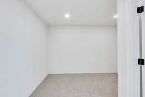 Carpeted empty room featuring recessed lighting