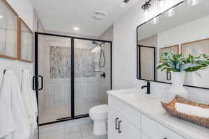 Full bath featuring vanity, a stall shower, recessed lighting, and tile patterned floors
