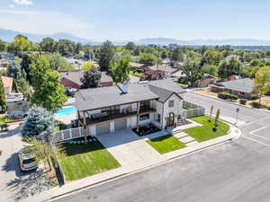 Aerial view of property and surrounding area featuring a mountainous background