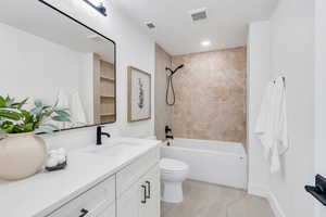 Bathroom with vanity, shower / bathtub combination, and recessed lighting