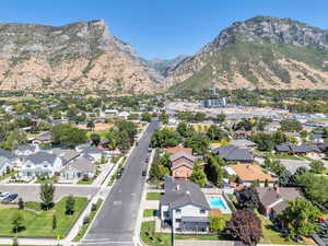 Aerial view of property and surrounding area featuring nearby suburban area and mountains