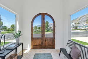Entryway featuring a mountain view, french doors, and arched walkways