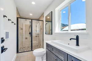 Full bathroom with a shower stall, vanity, tile patterned flooring, and recessed lighting
