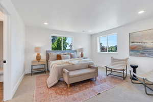 Carpeted bedroom featuring multiple windows and recessed lighting