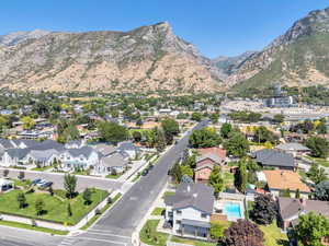 Aerial view of property and surrounding area with a mountain backdrop and nearby suburban area