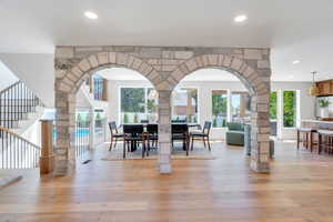 Dining space featuring light wood-type flooring, healthy amount of natural light, stairs, and recessed lighting