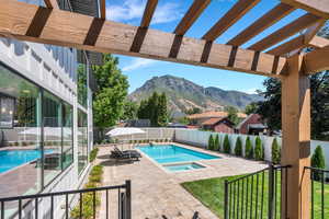View of swimming pool featuring a mountain view, a fenced backyard, a pergola, a patio, and a pool with connected hot tub