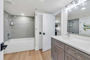 Full bathroom with recessed lighting, wood finished floors, shower / tub combination, and vanity