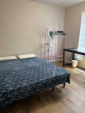 Bedroom with hardwood / wood-style floors and baseboards