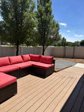 Deck with an outdoor living space and a fenced backyard