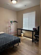 Bedroom with wood finished floors and a textured ceiling