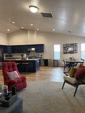 Living room featuring lofted ceiling, LVP floors, and recessed lighting