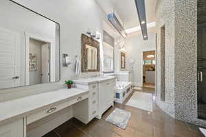 Full bath featuring two vanities, a shower stall, tile patterned flooring, and recessed lighting