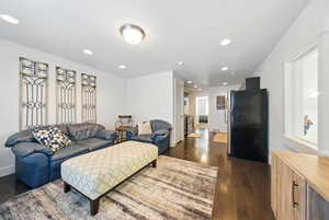 Living room with dark wood-style floors and recessed lighting