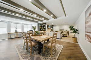 Dining space with recessed lighting, beam ceiling, wood finished floors, and built in shelves