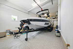 Garage featuring baseboards and a garage door opener