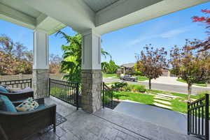Covered porch featuring a lawn