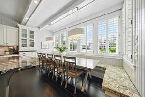 Dining area featuring beamed ceiling and dark wood-style flooring
