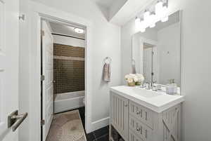 Full bathroom with tile patterned floors, vanity, and shower / bathtub combination