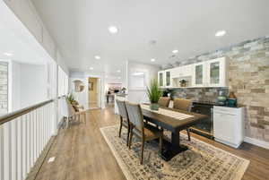 Dining room with wine cooler, light wood-style floors, and recessed lighting