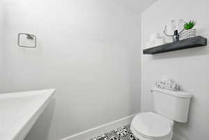 Bathroom with toilet and baseboards