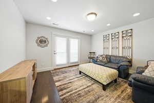 Living area featuring dark wood finished floors and recessed lighting