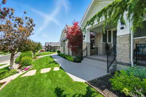 View of green lawn featuring covered porch and a residential view