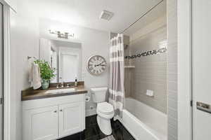 Full bathroom with a textured ceiling, tile patterned flooring, vanity, and shower / bath combo