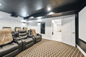 Cinema room with dark colored carpet, recessed lighting, and a textured ceiling