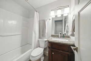 Bathroom with shower / bath combination with curtain and vanity