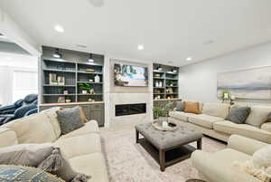 Living area with a fireplace, built in features, and recessed lighting