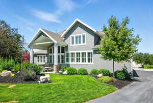View of front of property featuring roof with shingles, stucco siding, a front yard, and a patio area