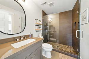Full bath featuring a shower stall, vanity, a textured ceiling, and tile patterned flooring
