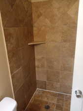 Bathroom with a tile shower and toilet