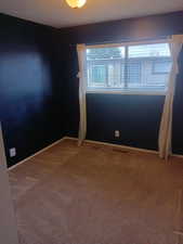 Carpeted empty room with a textured ceiling