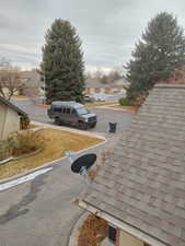 View of asphalt street featuring a residential view, street lighting, and curbs