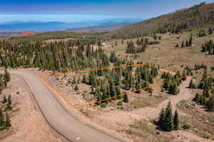 Aerial overview of property's location with a mountain backdrop and property boundaries highlighted