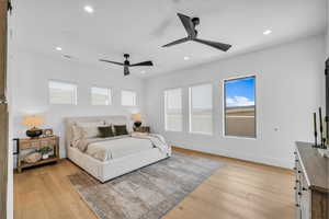Bedroom featuring light wood finished floors, multiple windows, recessed lighting, and a ceiling fan