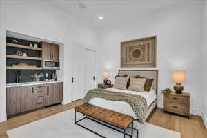 Bedroom with light wood finished floors, a closet, and recessed lighting