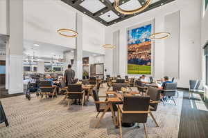 Carpeted dining room featuring a towering ceiling, coffered ceiling, beam ceiling, and recessed lighting