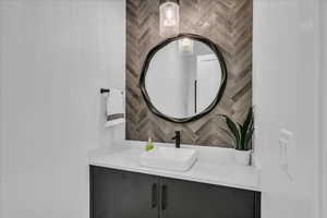 Bathroom featuring tasteful backsplash and vanity