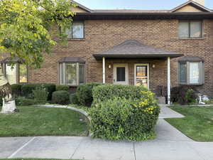 View of front of house with a front lawn and brick siding