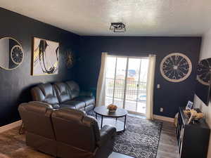 Living room with a textured ceiling and dark wood-style flooring