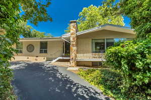 Ranch-style home with brick siding, crawl space, a chimney, and driveway