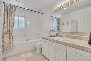 Bathroom featuring tiled shower / bath, vanity, and tile patterned floors