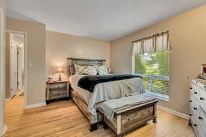 Bedroom with light wood finished floors and baseboards