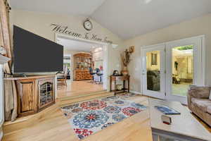 Living area with wood finished floors and lofted ceiling