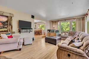 Living room featuring light wood-style flooring and a textured ceiling