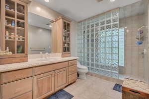 Bathroom with a walk in shower, vanity, recessed lighting, and tile patterned flooring