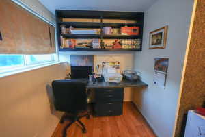 Office space with wood finished floors and built in desk